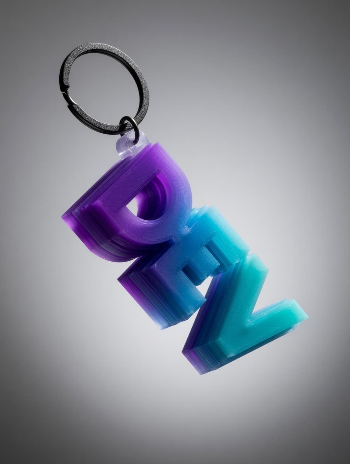 A 3D-printed name keychain in a purple-to-teal gradient, layer lines catching the light